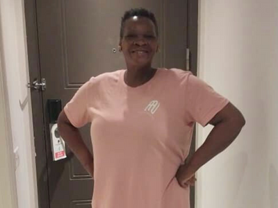 Toyin wearing the pink T-shirt dress, showing their support for Autism Among Us 